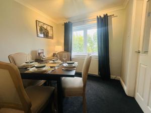 a dining room with a table with chairs and a window at 4 Caledonian Road in Fort William +11 photos