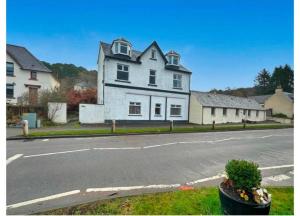 a large white house on the side of a street at Caledonian House Apartment in Fort William