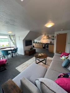 a living room with a couch and a table at Caledonian House Apartment in Fort William +14 photos