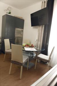 eine Küche mit einem Tisch und Stühlen sowie einem TV in der Unterkunft La Perla Di Caserta in Caserta