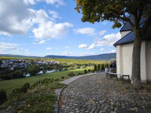 a bench next to a building with a view of a city at Garden Eden & Sauna in Neumagen-Dhron