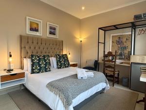 a bedroom with a bed and a desk and a chair at La Casa Blanca in Johannesburg +26 photos