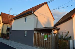 a building with a wooden fence next to a house at Juste un rayon de soleil Maison 6 personnes Alsace Centrale Proche Europa-park in Saasenheim