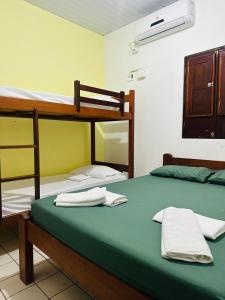 two bunk beds in a room with towels on them at Hostel Caribe Maragogi in Maragogi +12 photos