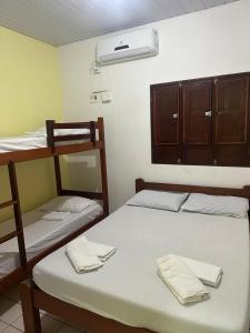a room with two bunk beds with towels on them at Hostel Caribe Maragogi in Maragogi