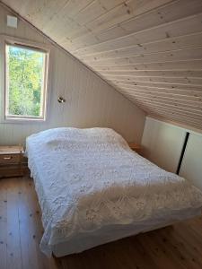 ein Schlafzimmer mit einem weißen Bett auf einem Dachboden in der Unterkunft Moderne hytte på Tingvoll nær sjø og turterreng in Tingvoll