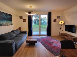 a living room with a couch and a tv at Lust auf Meer - Ferienwohnung mit Terrasse & Sauna in Garz