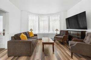 Una sala de estar con dos sofás y un televisor de pantalla plana. en Suite Jardin, en Quebec