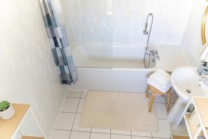 a white bathroom with a tub and a sink at Duplex cosy- proche centre ville in Colmar +4 photos