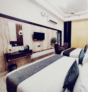 a hotel room with two beds and a television at Zhinlao Mount Resort in Gangtok