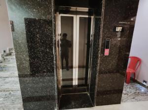 a man standing in a elevator in a building at Zhinlao Mount Resort in Gangtok +3 photos