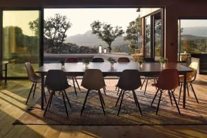 una sala da pranzo con tavolo e sedie su un tappeto di Lenza Barn Villa by Boutique Scenic Corsica a Viagenti Altre 12 foto
