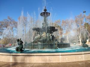 a fountain with a cat sitting in front of it at Plaza Independencia in Mendoza