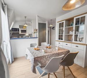 a kitchen and dining room with a table and chairs at Un souffle marin dans ce F2 à Cabourg in Cabourg +10 photos