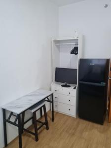 a small room with a table and a black refrigerator at Bella's Flats in Bayanihan in Pajak