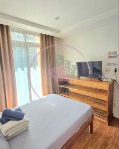 a bedroom with a bed and a flat screen tv at Megatower 3 4f29 Baguio Condo by Dei Gratia in Baguio