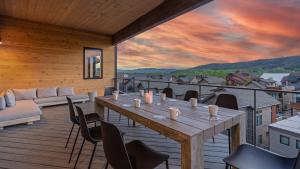 a wooden deck with a table and chairs on it at Friesian Chalet in Steamboat Springs