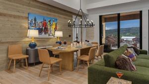 a living room with a table and a green couch at Friesian Chalet in Steamboat Springs