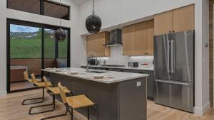 a kitchen with a stainless steel refrigerator and wooden cabinets at Friesian Chalet in Steamboat Springs