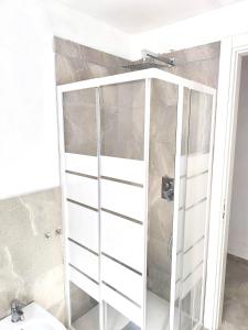 a shower stall with white doors in a bathroom at Eden Home just a few minutes from Lake Maggiore in Gravellona Toce