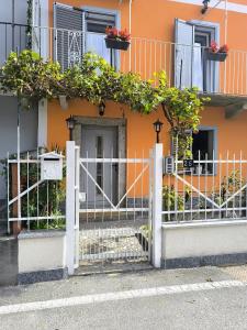 an orange building with a white gate and flowers at Eden Home just a few minutes from Lake Maggiore in Gravellona Toce