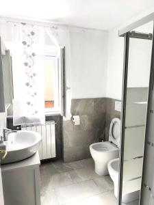 a white bathroom with a toilet and a sink at Eden Home just a few minutes from Lake Maggiore in Gravellona Toce +21 photos