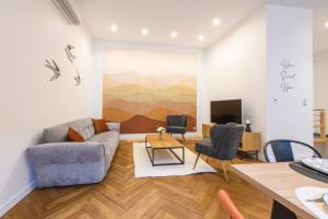 a living room with a couch and chairs and a table at Roanne Centre 6 pers Appartement Gare 10 min in Roanne