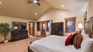 a bedroom with a large bed and a flat screen tv at Fuerza Grande in Steamboat Springs