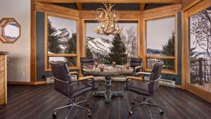 a dining room with a table and chairs and windows at Glacier Grande in Steamboat Springs +29 photos