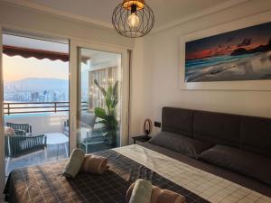 a bedroom with a bed and a view of the city at Sea&Skyline Suites Benidorm in Benidorm +20 photos