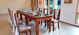 a wooden table with chairs and a long table with glasses at Osiligi White Resort in Kitengela  +36 photos