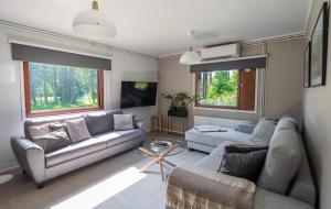 a living room with two couches and a tv at Ranua Haistila Retreat with Elegant Views & Sauna near Rovaniemi in Ranua