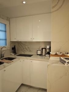 a white kitchen with white cabinets and a sink at Sea&Skyline Suites Benidorm in Benidorm