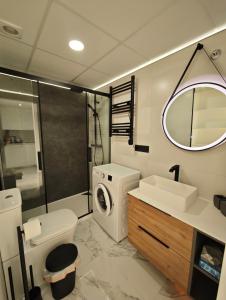 a bathroom with a toilet sink and a washing machine at Sea&Skyline Suites Benidorm in Benidorm