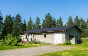 a small house with a garage in a yard at Ranua Haistila Retreat with Elegant Views & Sauna near Rovaniemi in Ranua