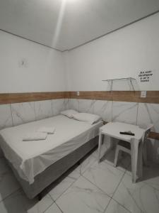 a bed and a table in a room at Hotel Contorno in Santa Inês