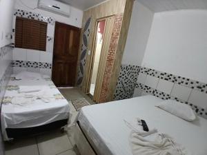 a room with two beds and a window in it at Hotel Contorno in Santa Inês