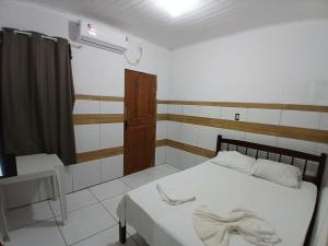 a bedroom with a white bed and a window at Hotel Contorno in Santa Inês