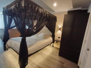 a bedroom with a canopy bed with black drapes at Romántica Suite entre tules in Arequipa
