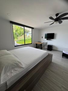 Un dormitorio con una cama grande y una ventana grande. en ZOI Eco Hotel y Glamping, en Manizales