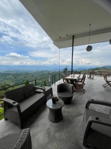 マニサレスにあるZOI Eco Hotel y Glampingのパティオ(ソファ、テーブル、椅子付)