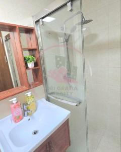 Un baño con ducha y lavabo blanco. en Megatower 3 5f29 Baguio Condo by Dei Gratia, en Baguio