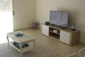 a living room with a flat screen tv on a cabinet at Cabanas Apartment in Tavira
