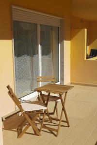 a wooden picnic table and a chair next to a window at Cabanas Apartment in Tavira