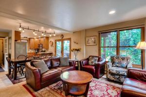 een woonkamer met lederen meubels en een keuken bij Great Raven Grande in Breckenridge