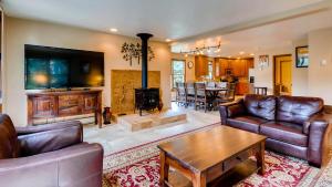 een woonkamer met lederen meubels en een open haard bij Great Raven Grande in Breckenridge