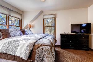 een slaapkamer met een bed en een flatscreen-tv bij Great Raven Grande in Breckenridge +81 foto's