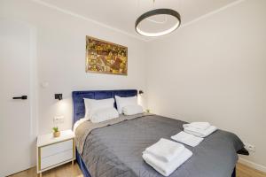 a bedroom with a blue bed with white towels on it at Sen Krasnala by FuzjaAparts in Wrocław