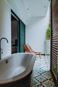 a bath tub in a bathroom with a tile floor at Ame Hotel Boutique & Spa in Playa del Carmen