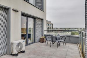 a patio with a table and chairs on a balcony at Sen Krasnala by FuzjaAparts in Wrocław